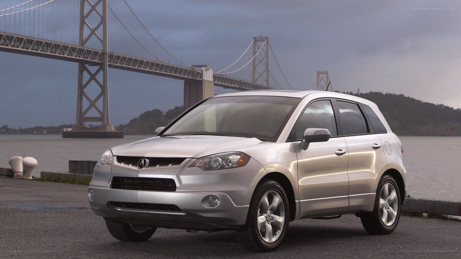 Silver Acura RDX by a bridge