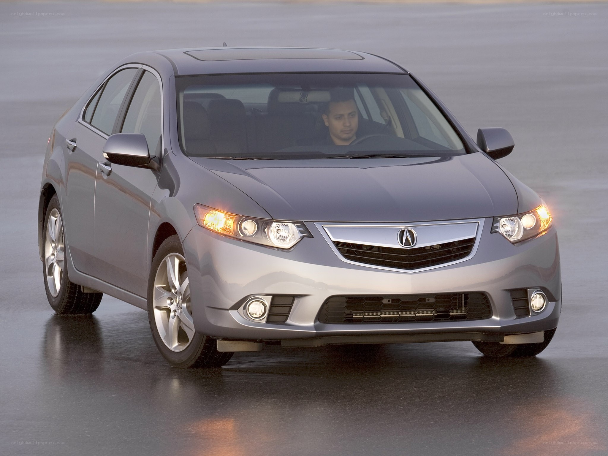 silver acura sedan on wet pavement