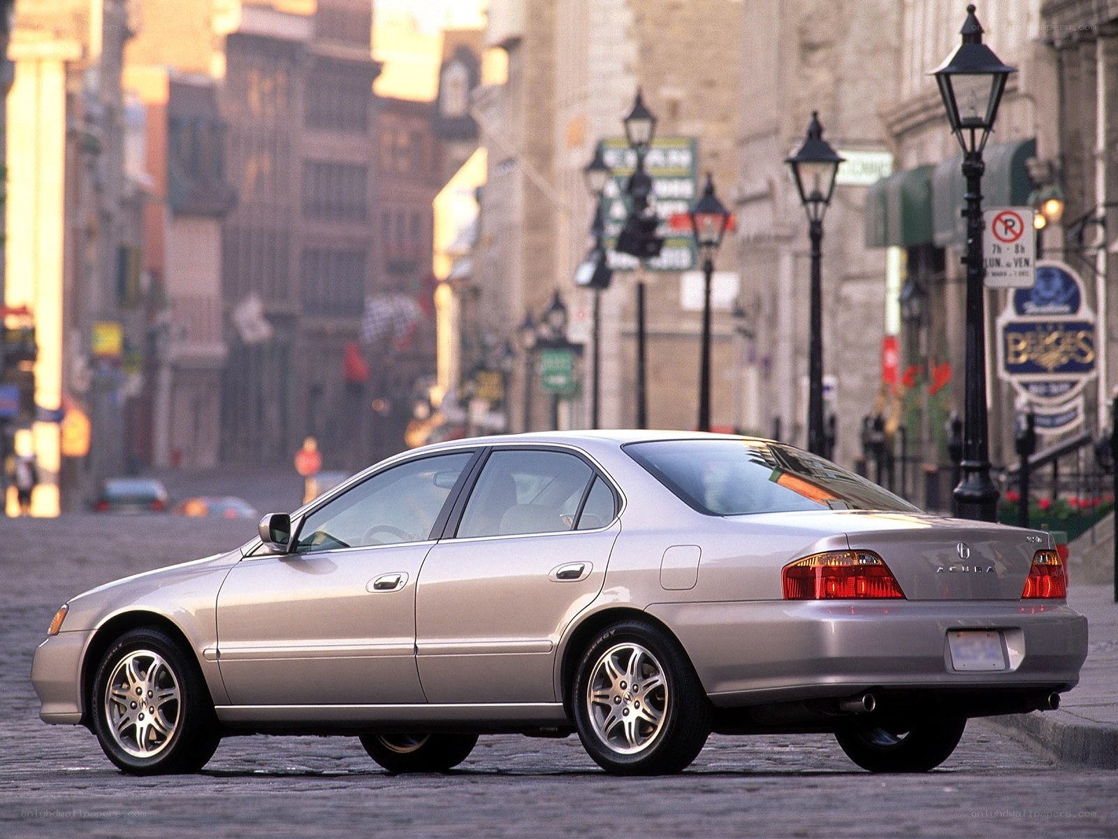 silver acura sedans on cobblestone street