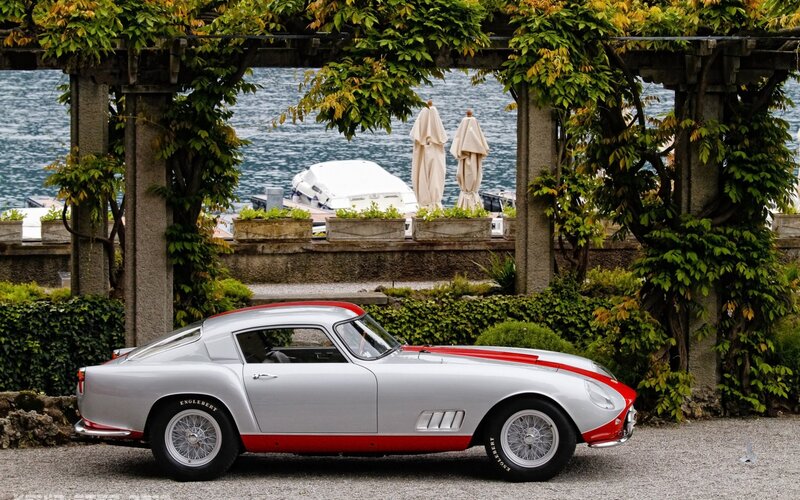 Silver and red classic car by the lake