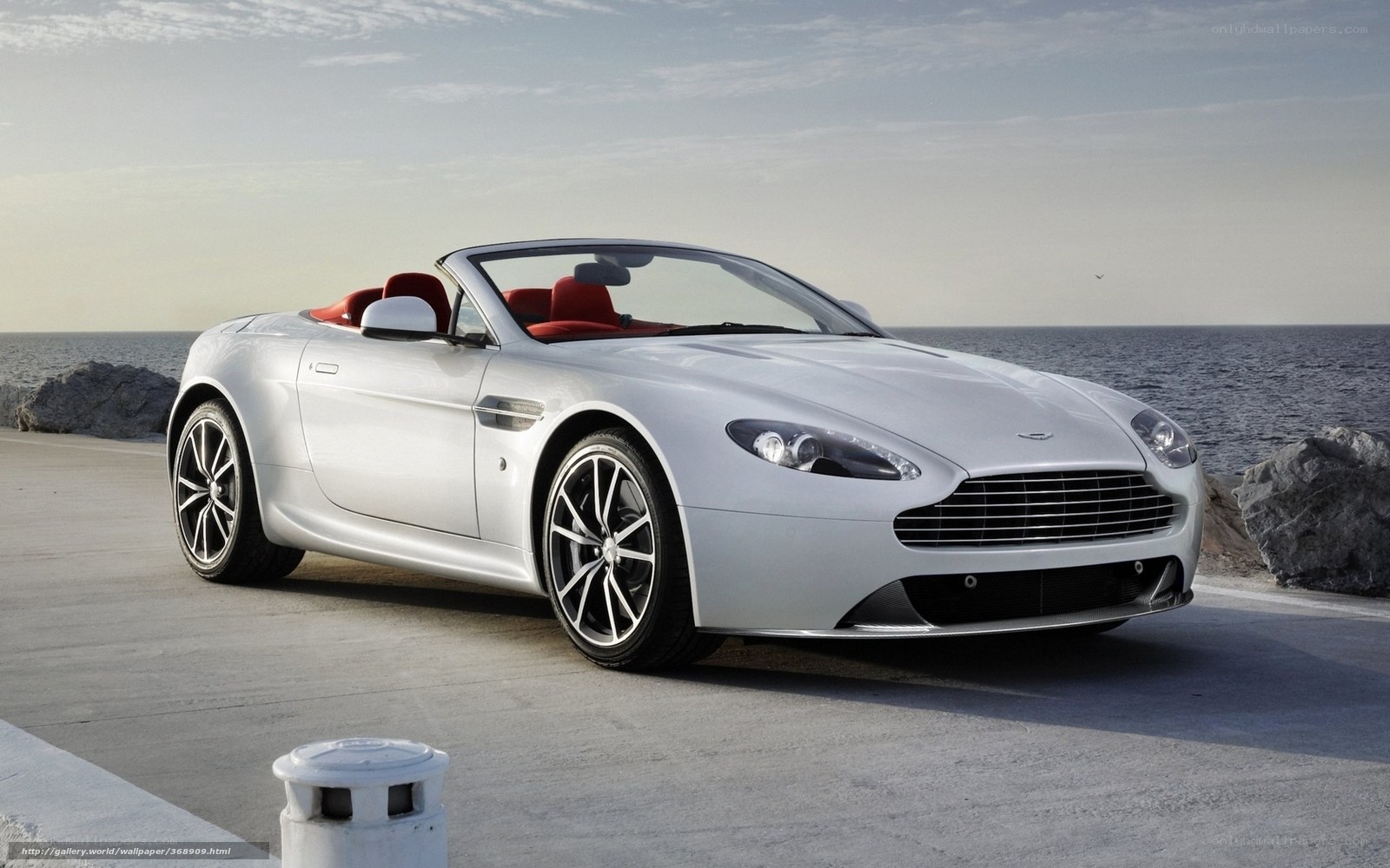 Silver Aston Martin convertible by the sea