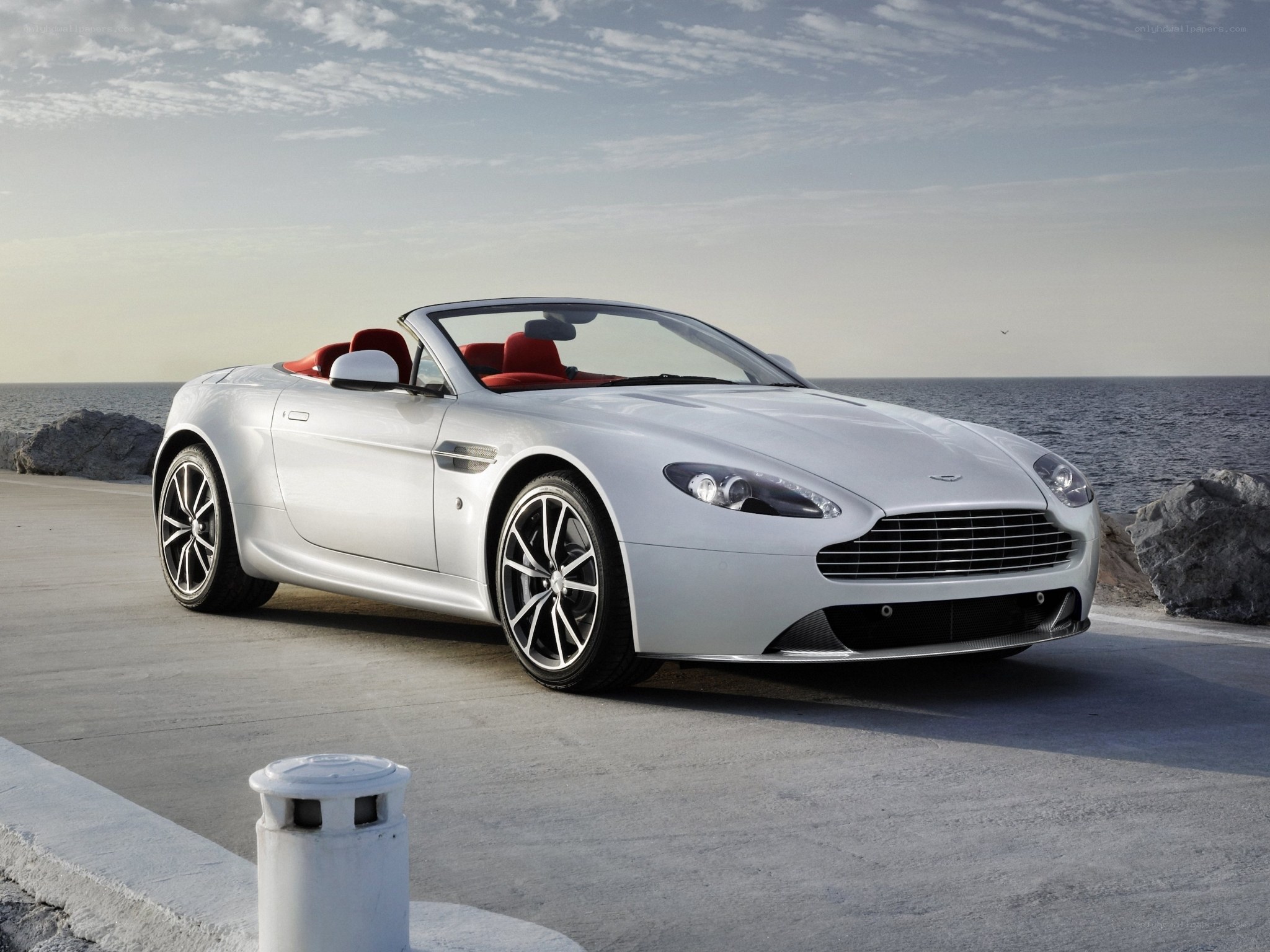 Silver Aston Martin convertible by the sea