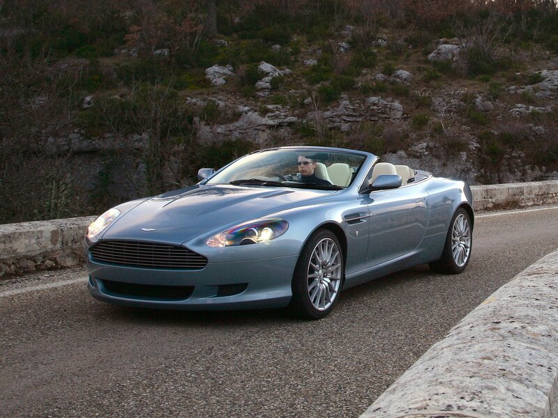 Silver Aston Martin convertible on road