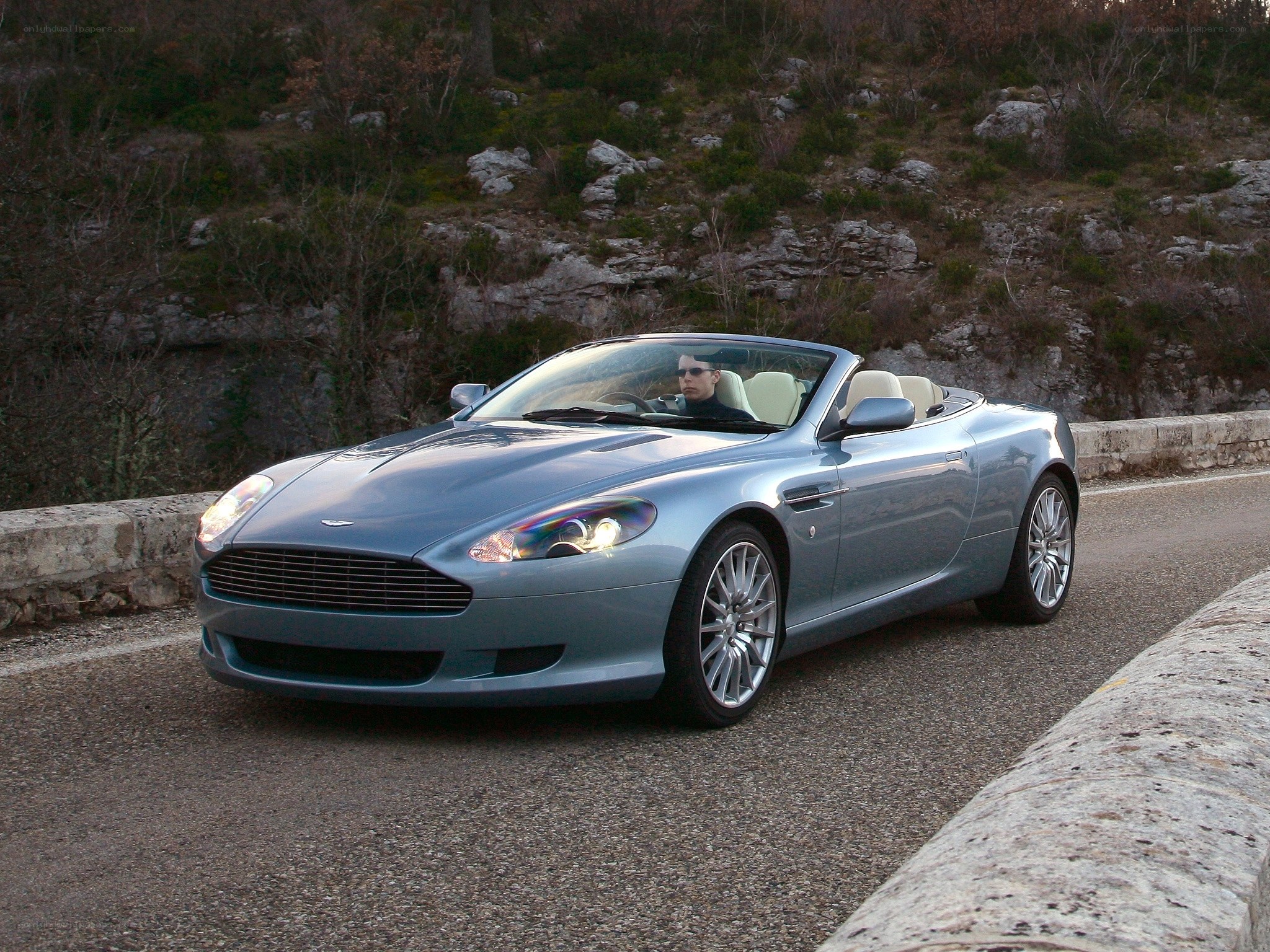 Silver Aston Martin convertible on road