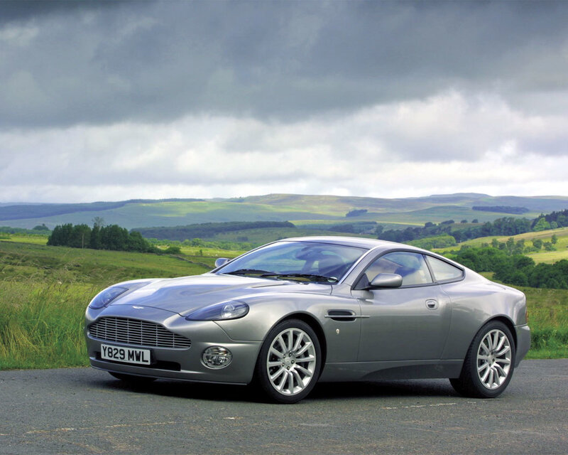 Silver Aston Martin in a scenic landscape