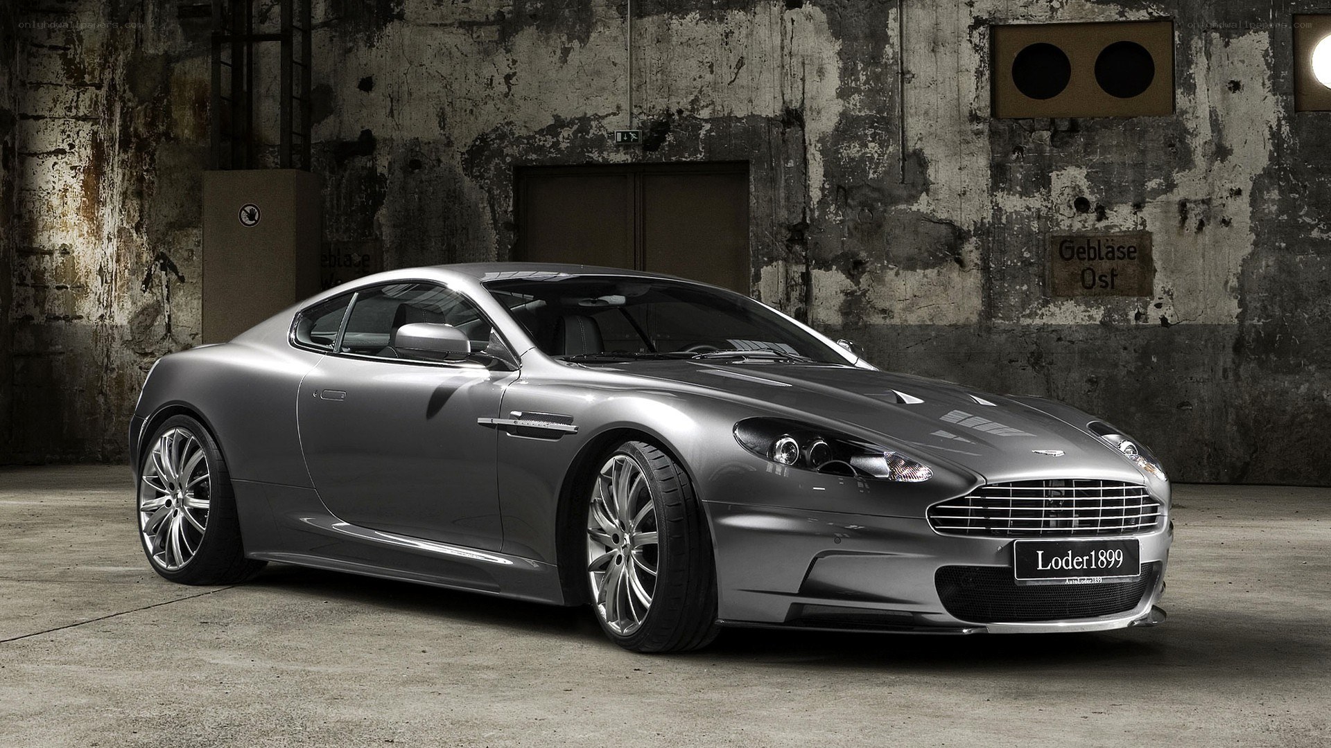 Silver Aston Martin in industrial setting