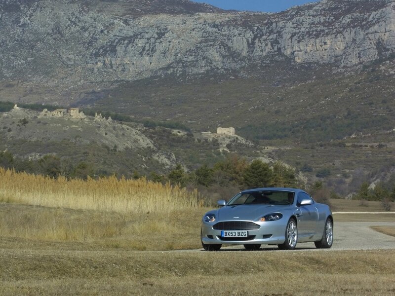 Silver Aston Martin on a country road