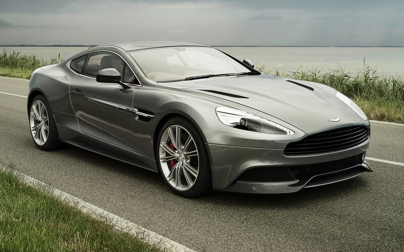 silver aston martin on coastal road