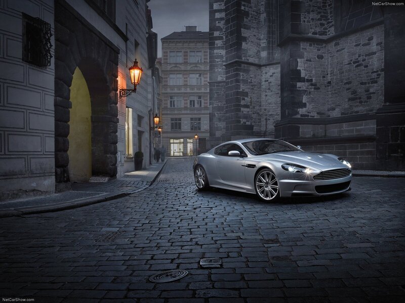 silver aston martin on cobblestone street