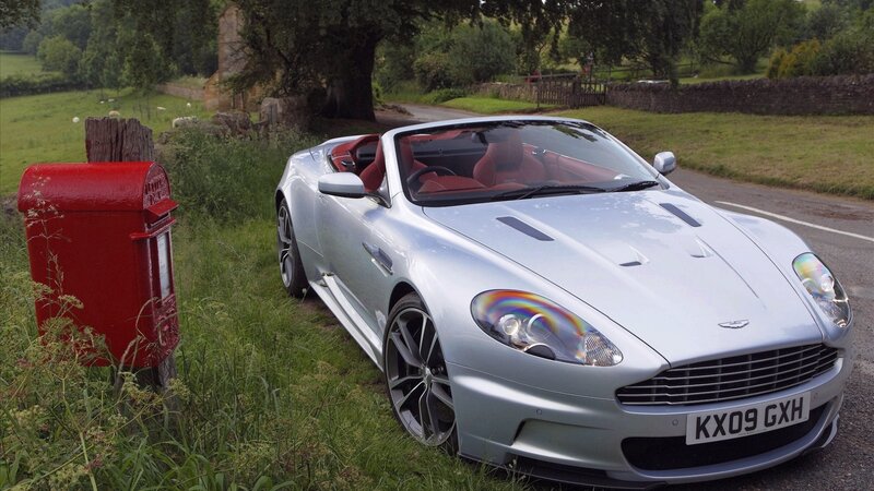 Silver Aston Martin on country road