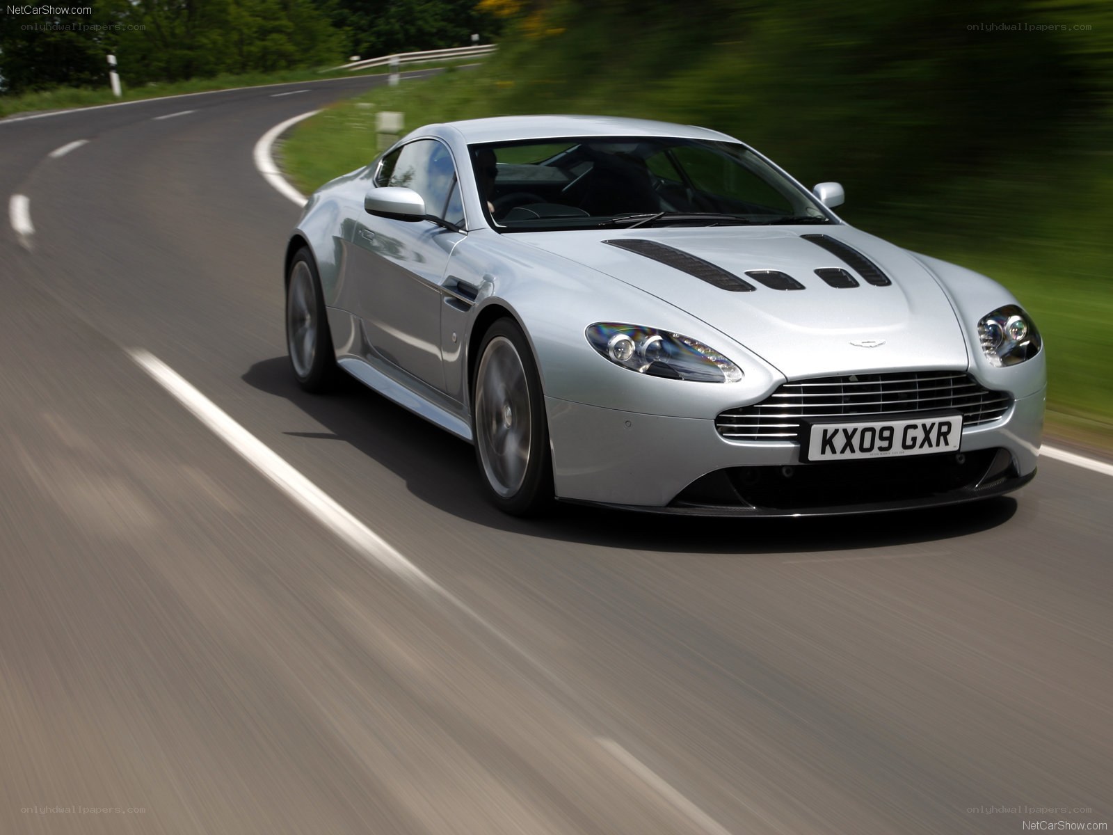 silver aston martin on winding road
