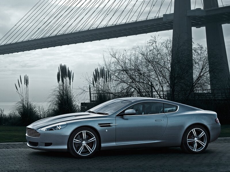 Silver Aston Martin under bridge