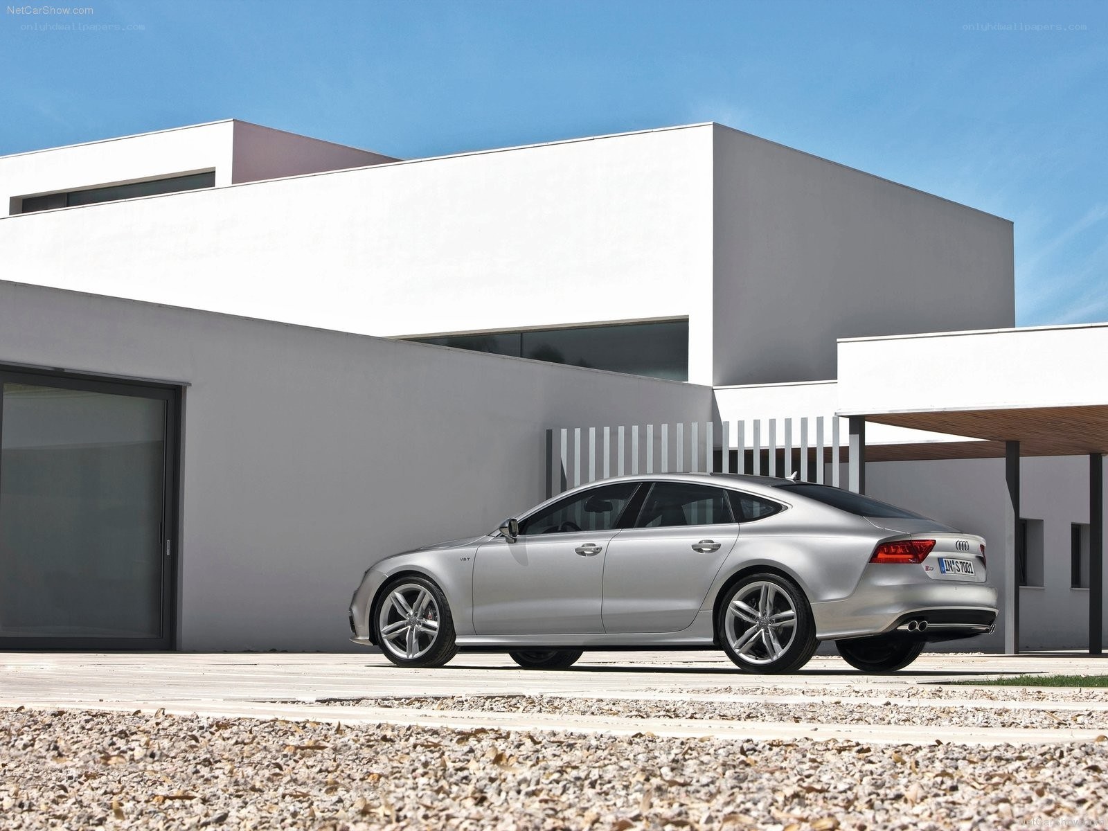 Silver Audi A7 parked outside modern house