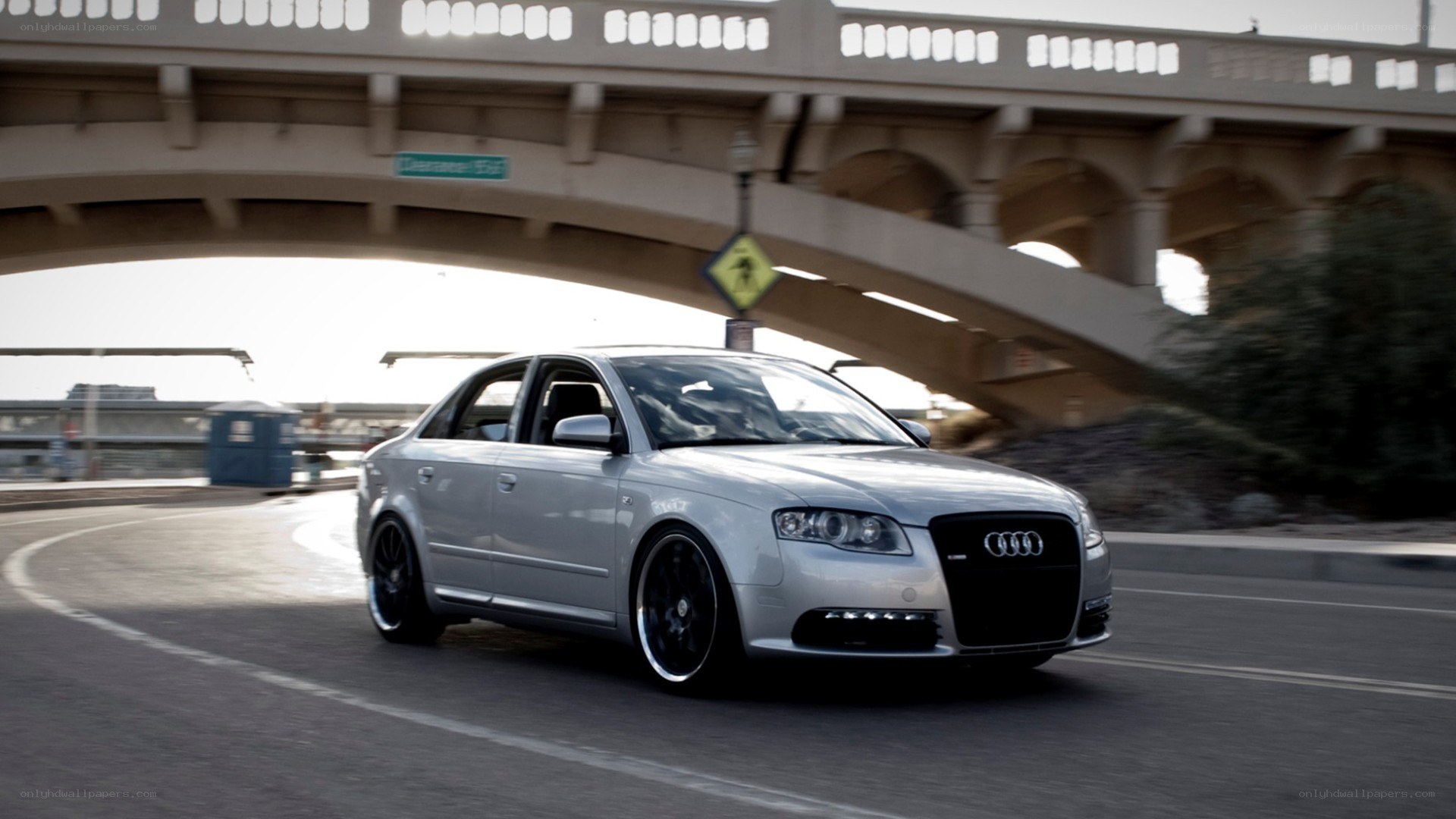 silver audi driving under bridge