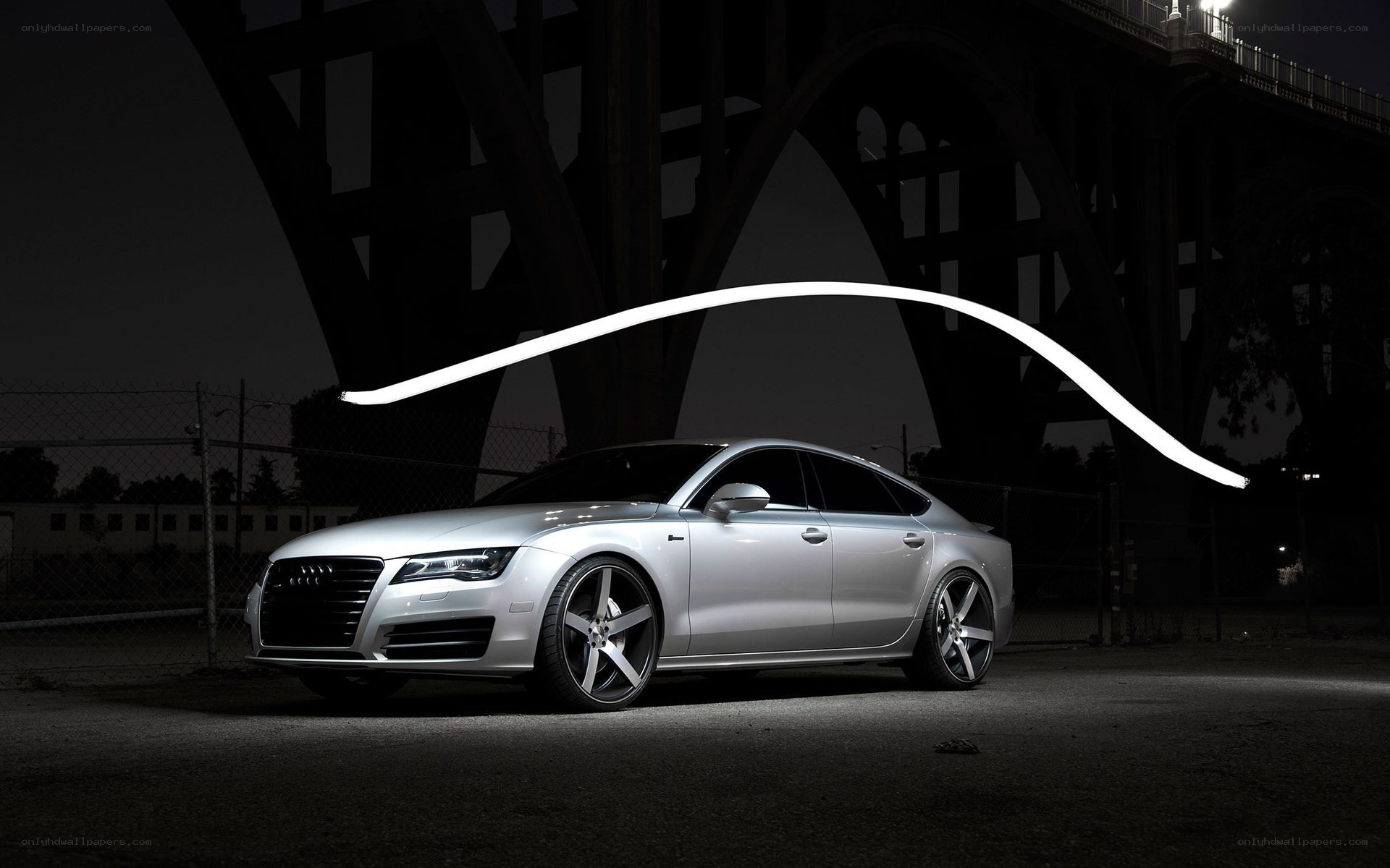 Silver Audi under bridge at night