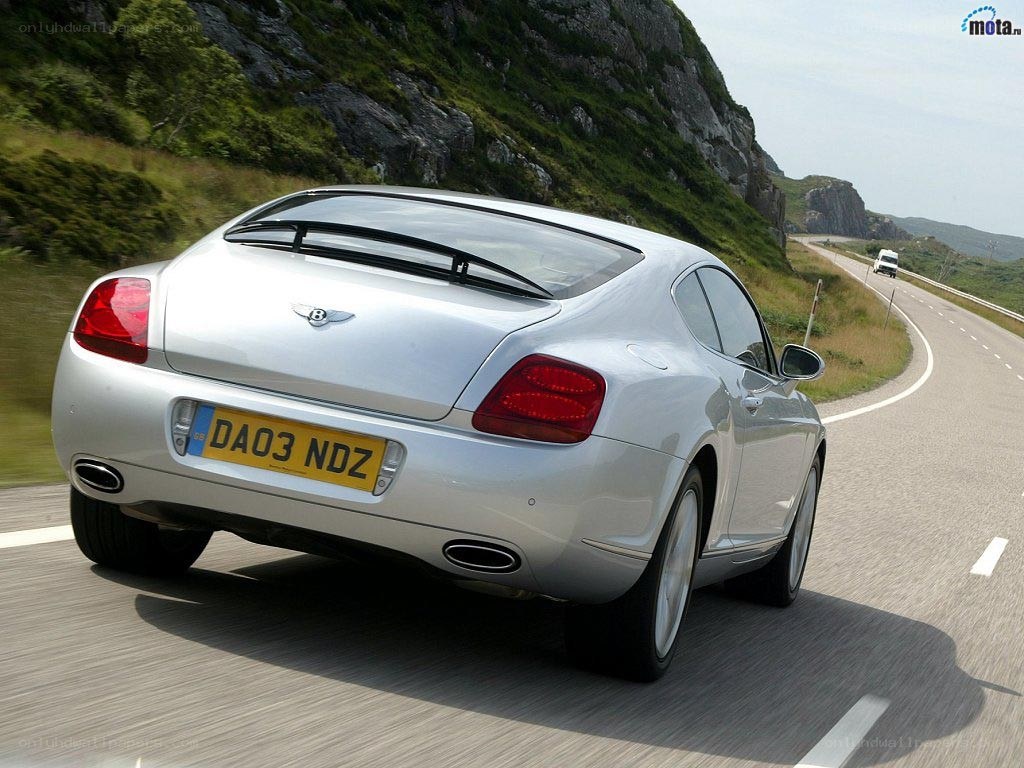 silver bentley driving on mountain road
