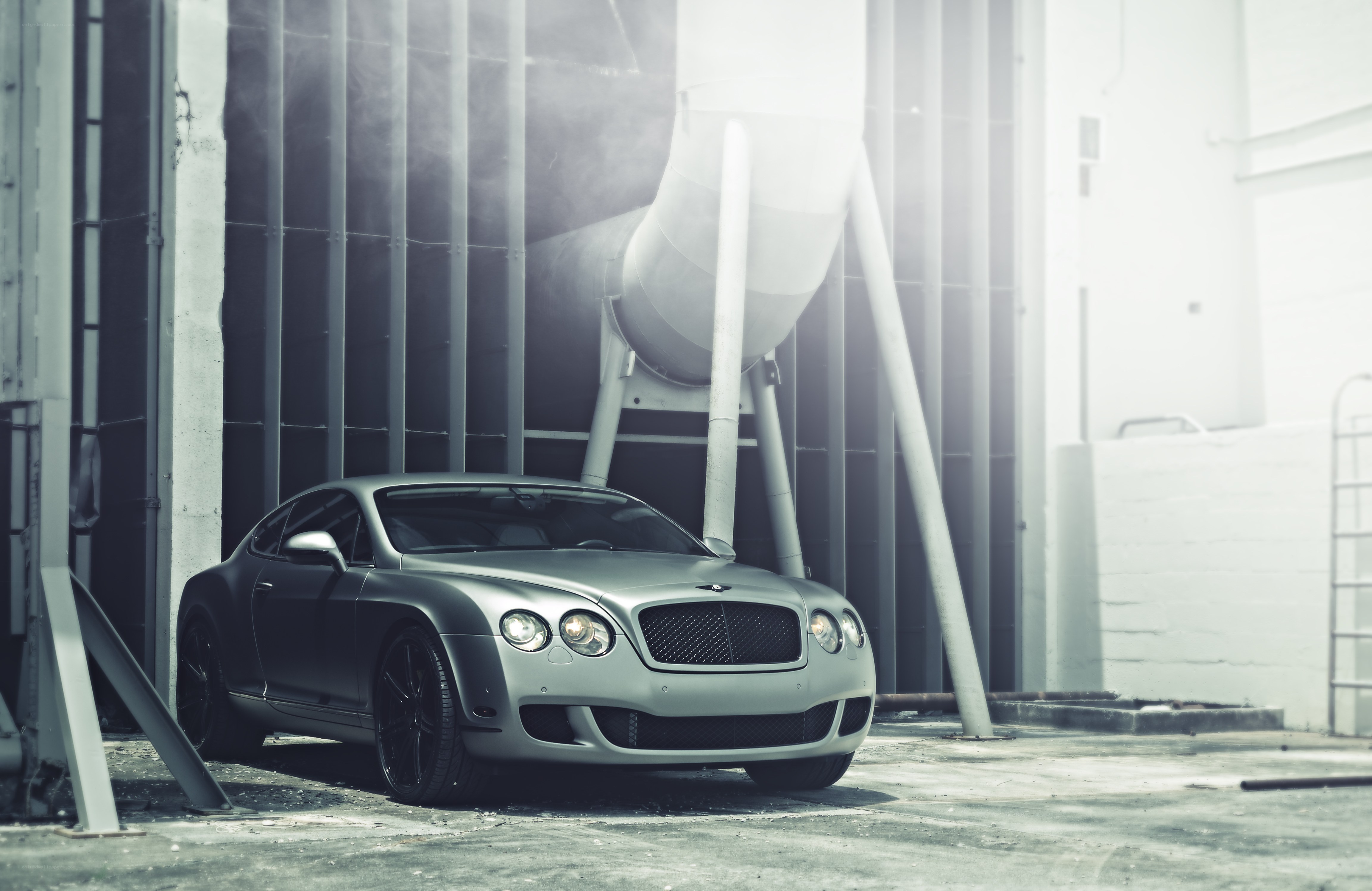 Silver Bentley in industrial setting