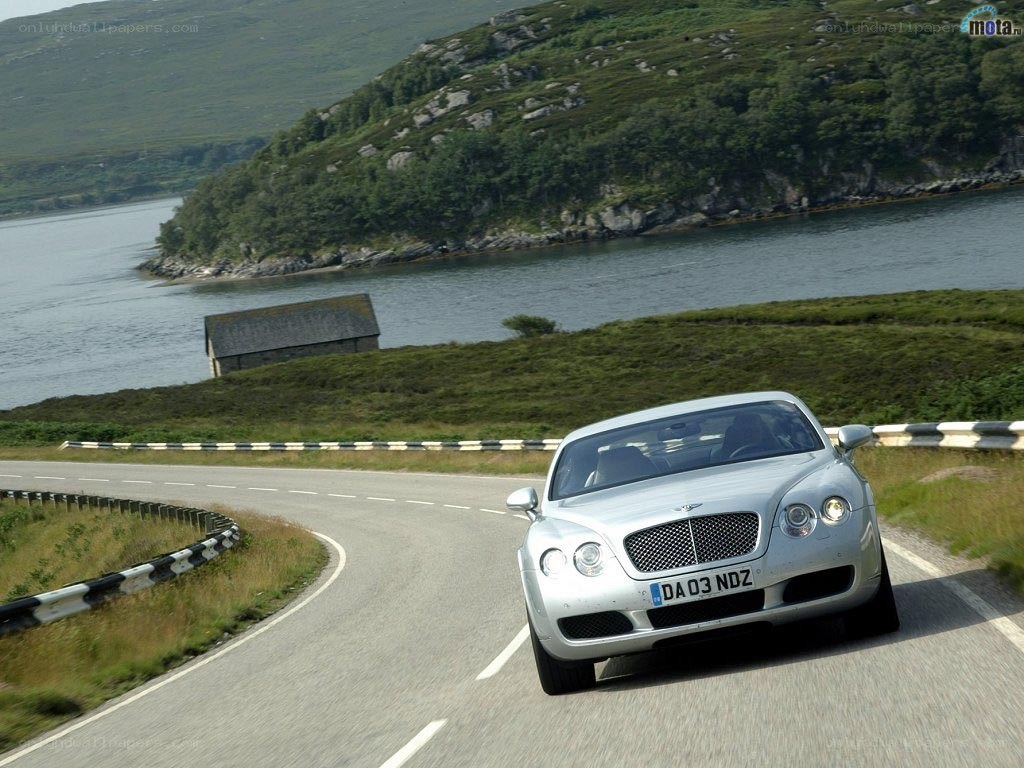 Silver Bentley on a coastal road