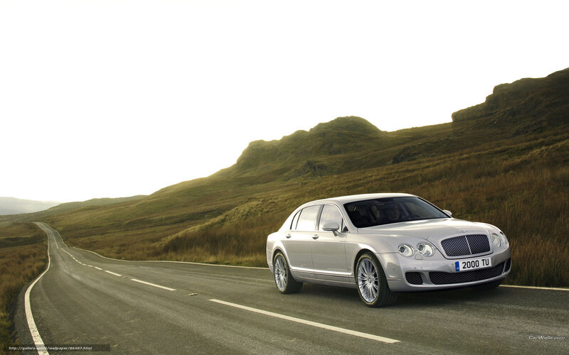 Silver Bentley on a winding road