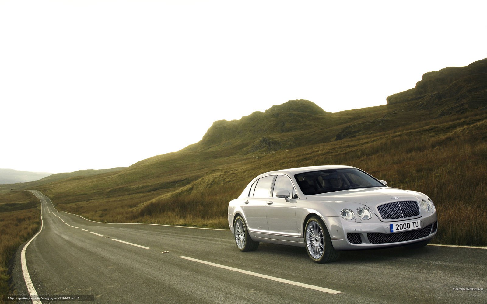 Silver Bentley on a winding road