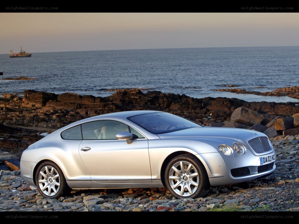 Silver Bentley on rocky shore