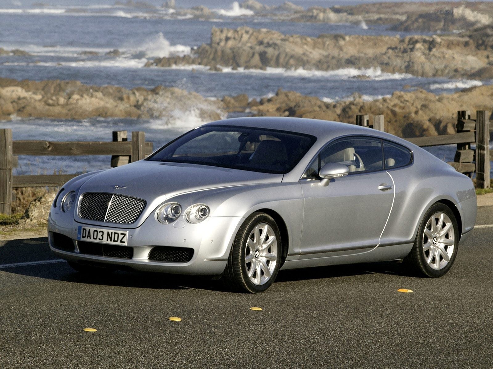 Silver Bentley parked by the sea