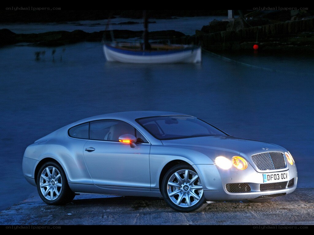 Silver Bentley parked by the water