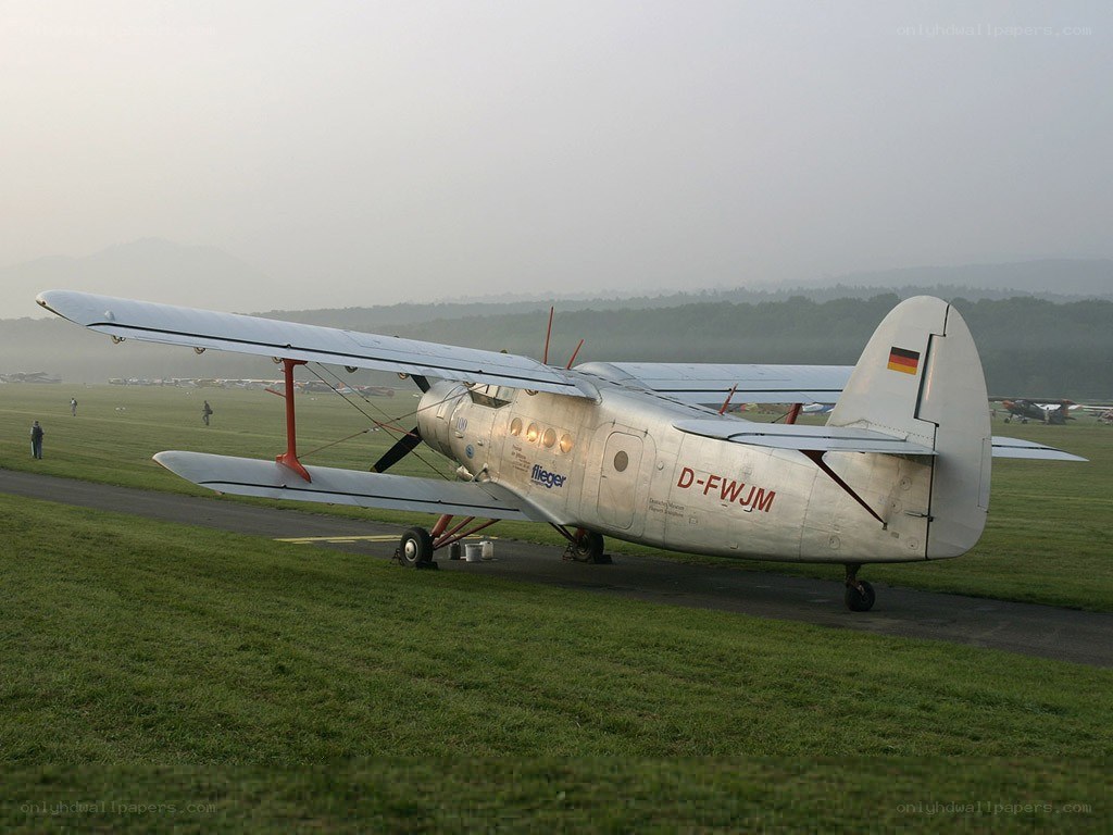 Silver biplane on airfield