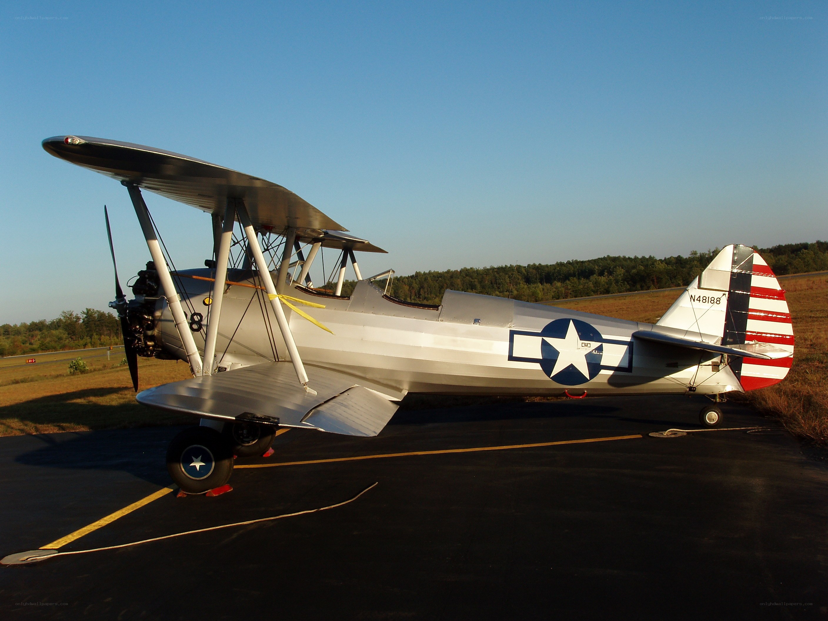 Silver biplane on tarmac