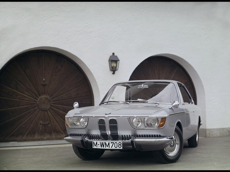 Silver BMW 2000 parked in front of building