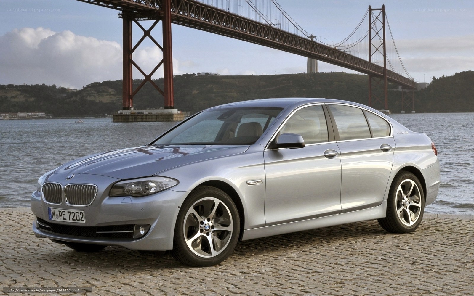 Silver BMW 5-Series by a bridge