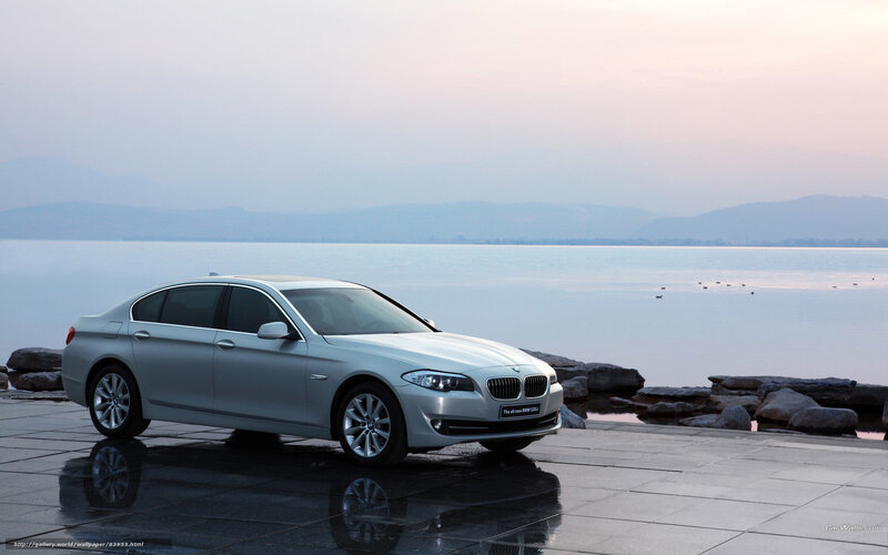 Silver BMW 5 Series by the lake