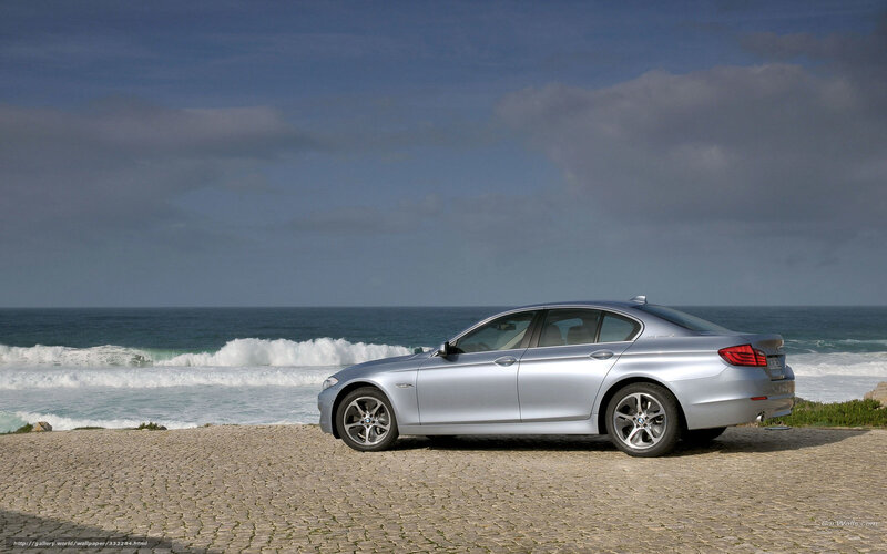 Silver BMW 5-Series by the sea