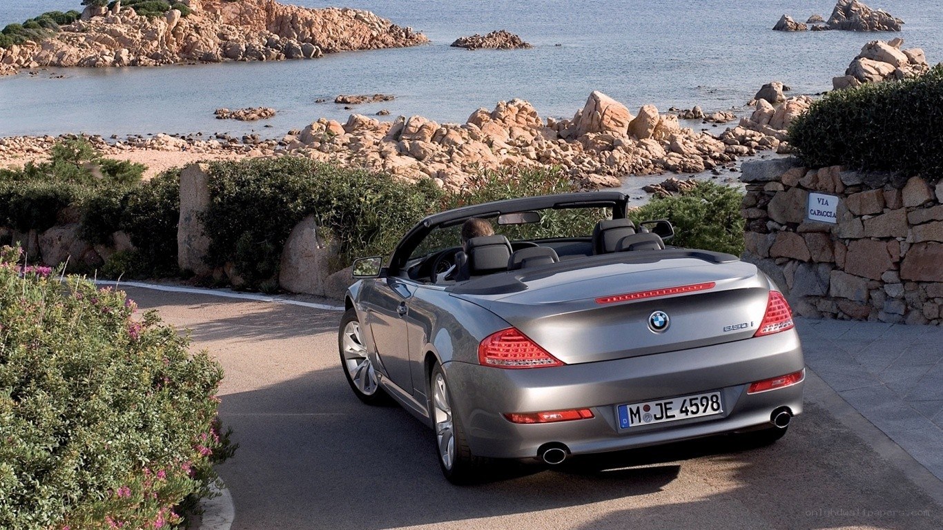 Silver BMW convertible by the sea
