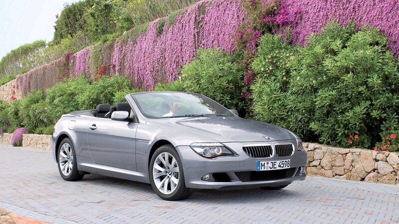 Silver BMW convertible on a scenic road