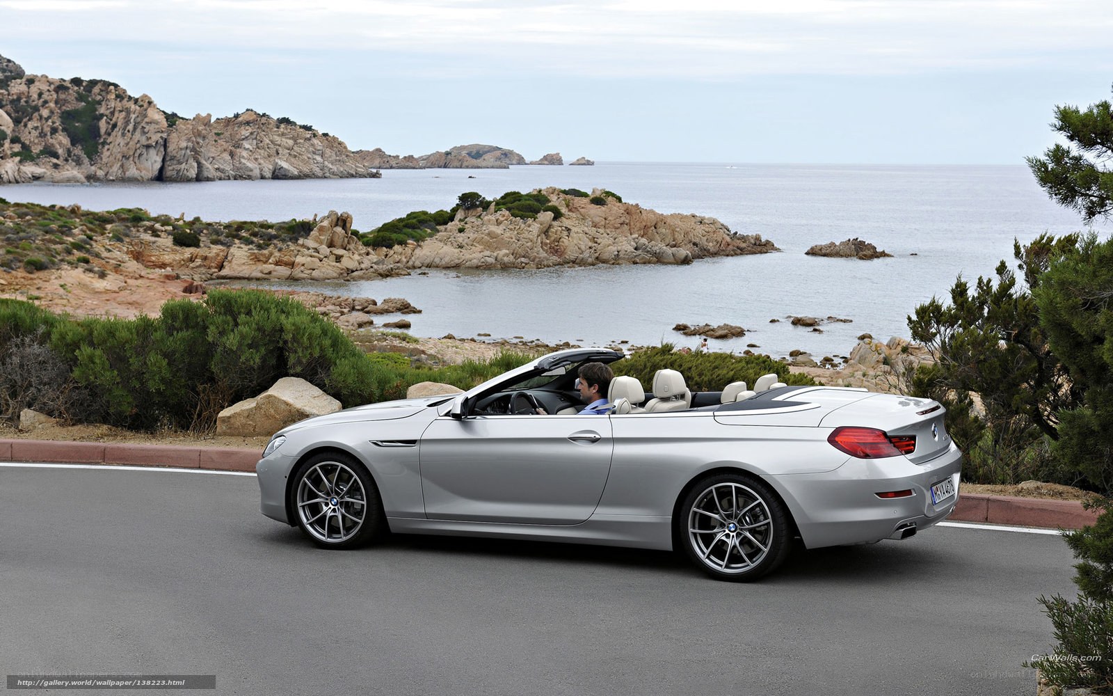 Silver BMW convertible on coastal road