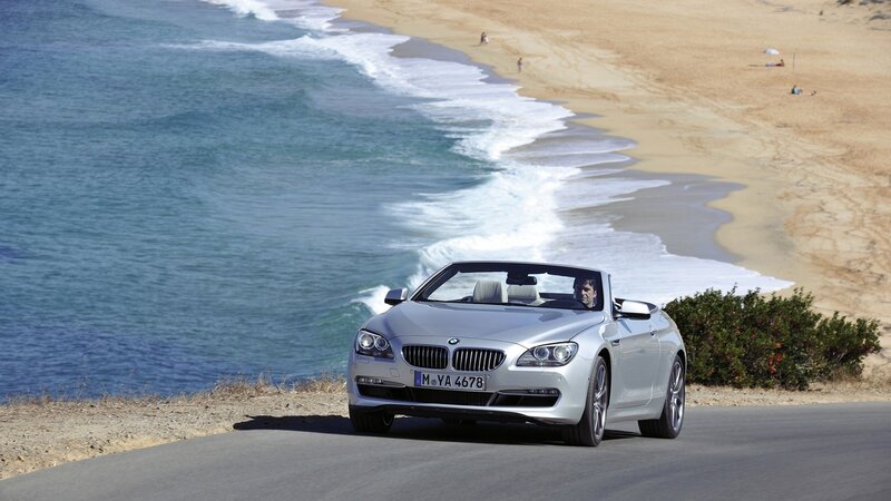 Silver BMW convertible on coastal road