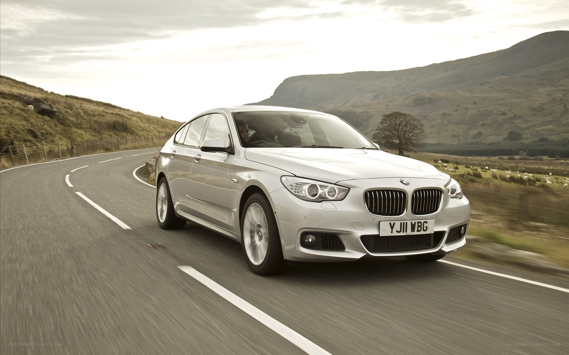 silver bmw driving on a road
