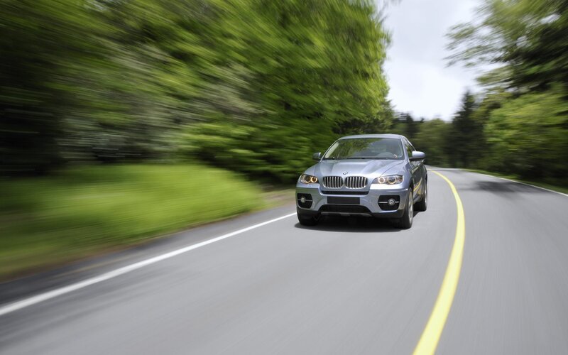 Silver BMW driving on a road