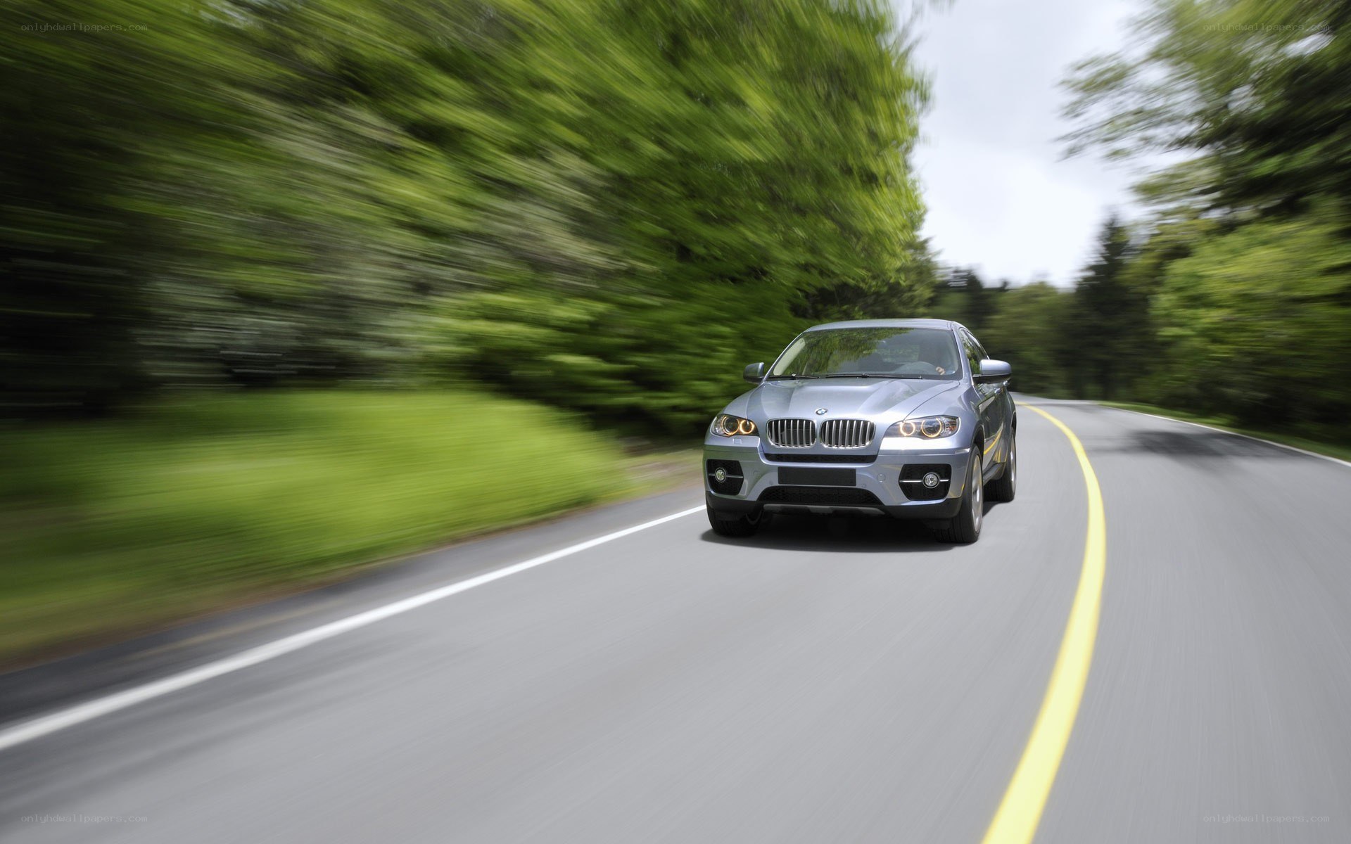 Silver BMW driving on a road