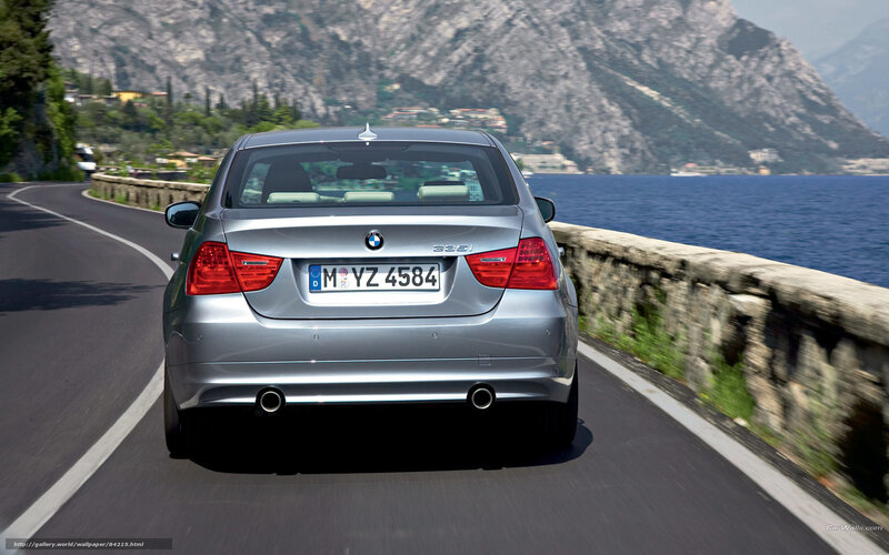 silver bmw driving on coastal road