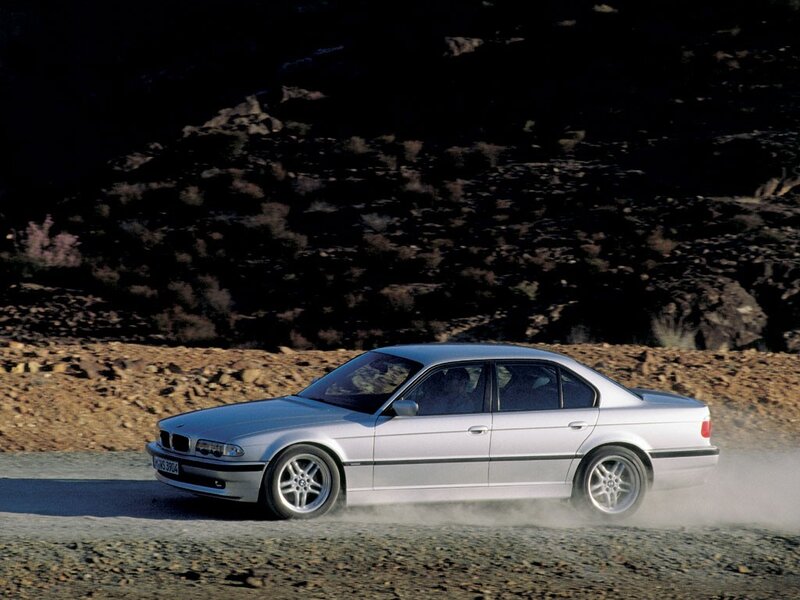 silver bmw driving on dirt road