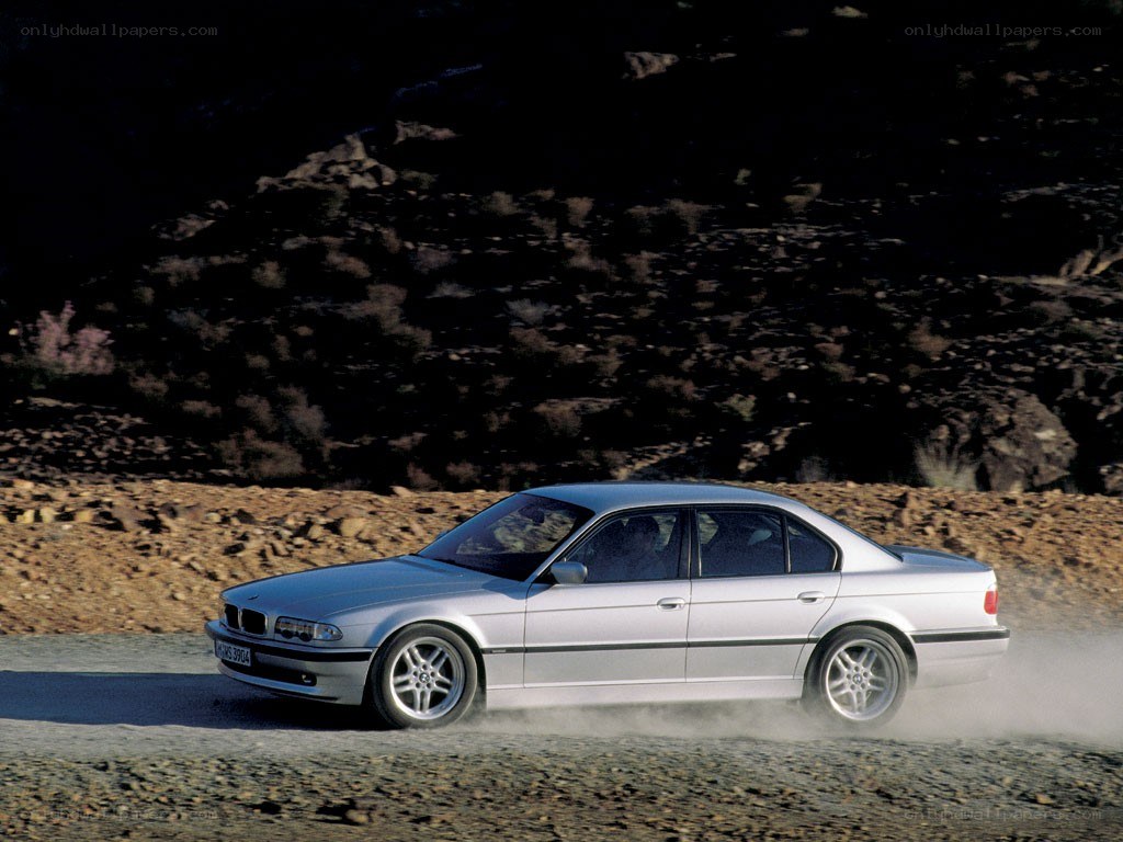 silver bmw driving on dirt road