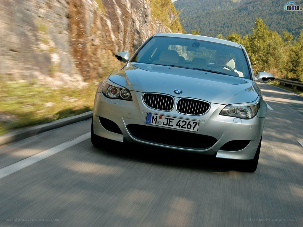 silver bmw driving on mountain road