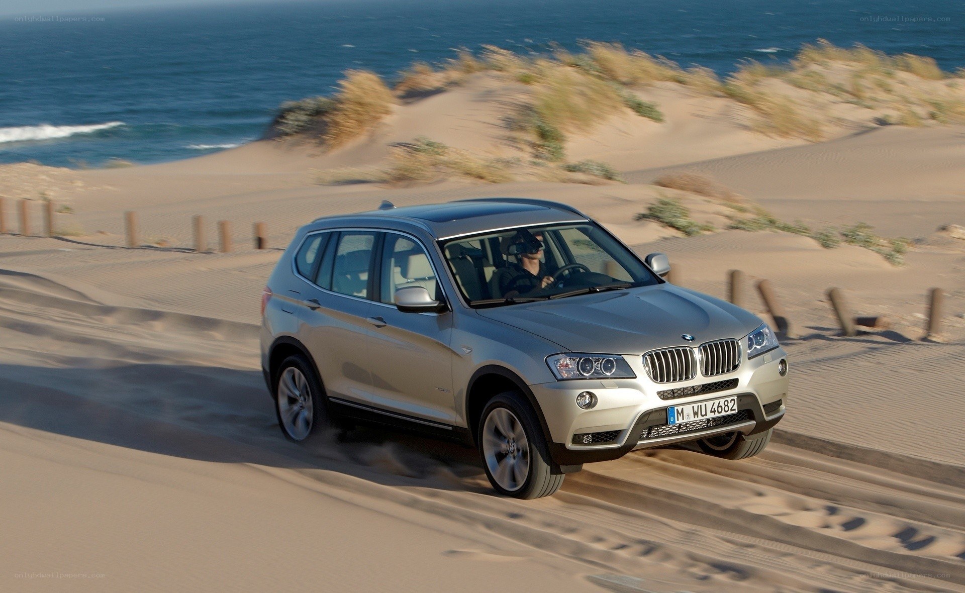 Silver BMW driving on sand