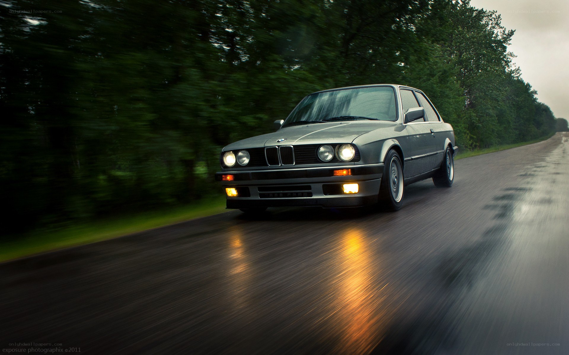 silver bmw driving on wet road