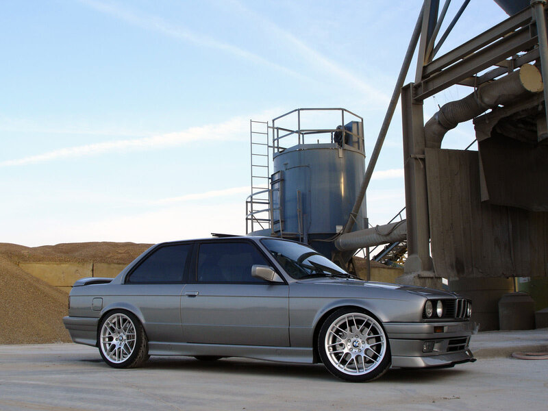 silver bmw e30 in industrial setting