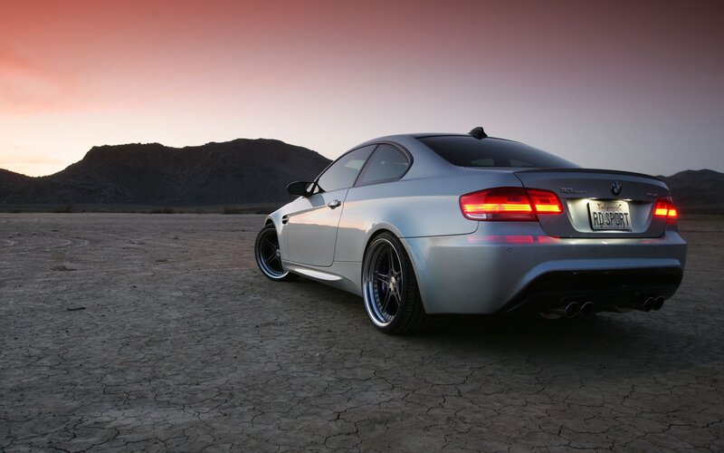 silver bmw in desert at sunset