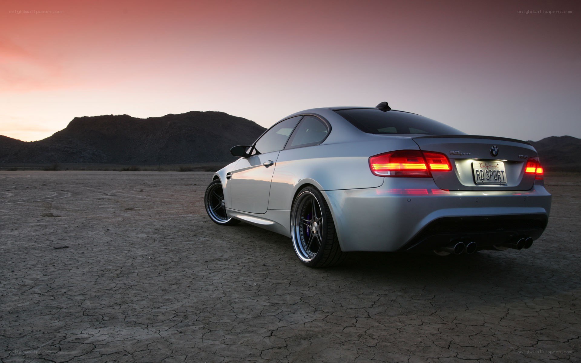 silver bmw in desert at sunset