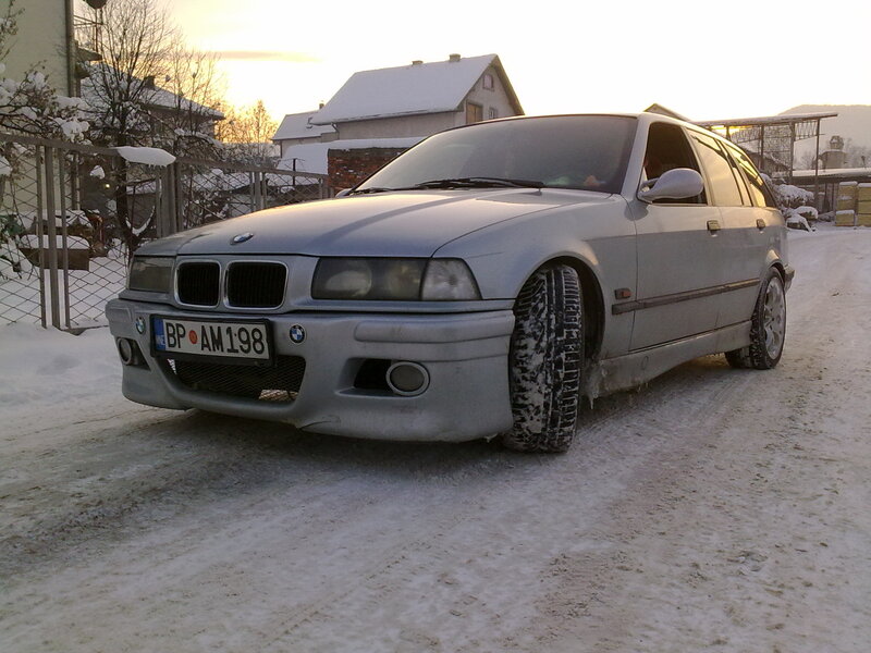 Silver BMW in snowy driveway